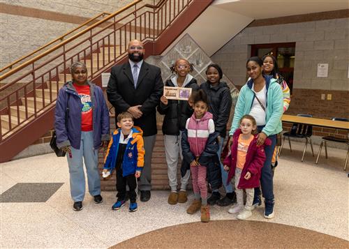 Erie High's Stairclimber Ne"asiah Aukett, posing with her plaque and family members and Mr. Nickson.