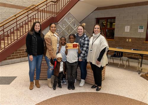 Edison Stairclimber RodJerique Thompson posing with his plaque, family members, and Principal Diane Sutton.