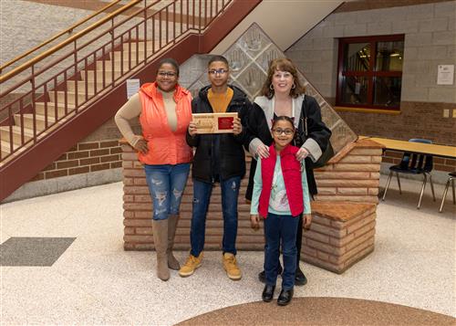 Strong Vincent Stairclimber Jeremi Rios Carmona posing with his plaque, family members, and Principal Gloystein