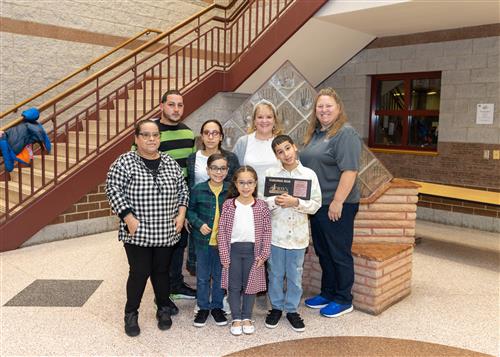 Chrisdenier Marrero Rivera, Diehl's November Stairclimber, poses with his plaque, family members and school staff.