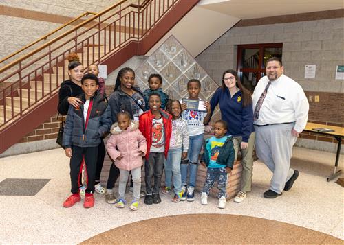 King Bibbs, Connell's November Stairclimber, poses with his plaque, family members and Principal Causgrove.