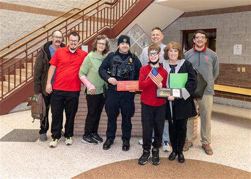 Joseph Horomanski, Strong Vincent's November Stairclimber, poses with his plaque, family members and district staff.
