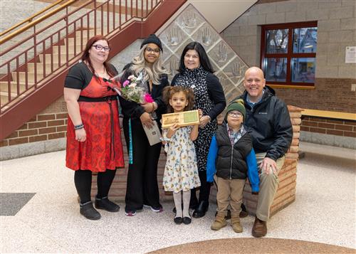 Harding's March Stairclimber, Charlotte Robinson, posing with her plaque, family members and school staff.