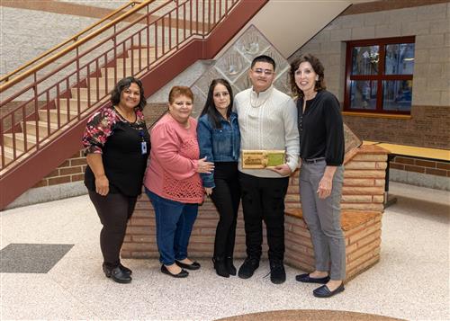 PJD's March Stairclimber, Kevin Martinez, posing with his plaque, family members and school staff.