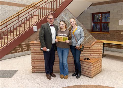 Collegiate Academy's March Stairclimber, Mirianna Rodriguez, posing with her plaque, a family member and Dean Jim Vieira.