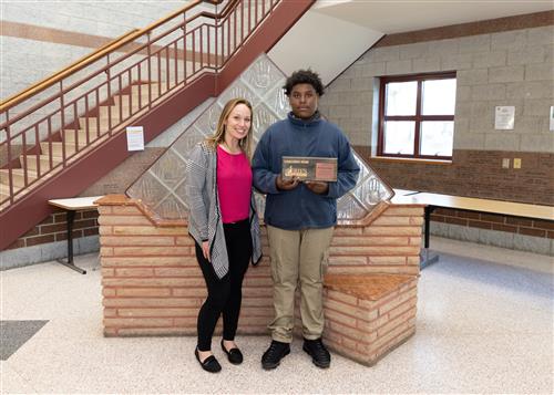 Da'Larrion Lemon, Wilson Middle School's April Stairclimber, poses with his plaque and an assistant principal.