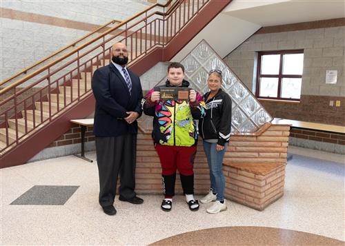 Dominic Simon, Strong Vincent's April Stairclimber, poses with his plaque, a family member, and DEI Coordinator Nickson.