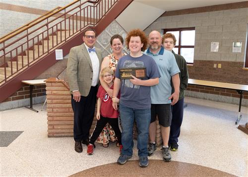 Gary Thompson, Collegiate Academy's April Stairclimber, posing with his plaque, family members and Dean Vieira.