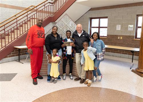 Tyshaun Gunn, Harding Elementary's April Stairclimber, poses with his plaque, family members, and Assistant Principal Yonkers
