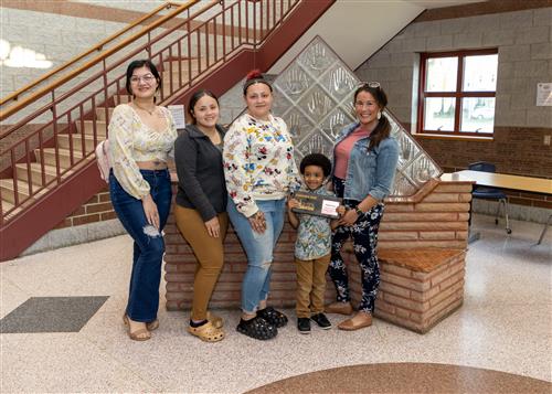 Dimetri King, Edison Elementary's May 2023 Stairclimber, poses with his plaque, family members and Assistant Principal Kloss.