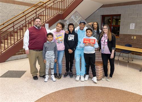 Tyzeer Simmelkjar, JoAnna Connell's February Stairclimber, poses with his plaque, family members, and school staff.