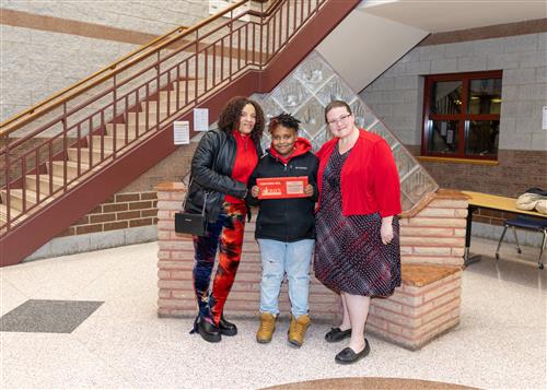 Khameron Segretti, Lincoln's February Stairclimber, poses with his plaque, a family member, and Principal Carol Jo Huffman.