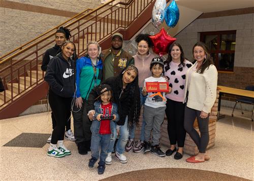 Josiah Campbell, Edison's Stairclimber for February, poses with his plaque, family members, and school staff.