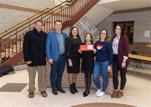 Iryna Semeniaka, Wilson's February Stairclimber, poses with her plaque, family members, and school staff.
