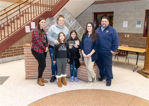 Alayna Havelka, Connell's Stairclimber for December, poses iwth her plaque, family members and school staff.