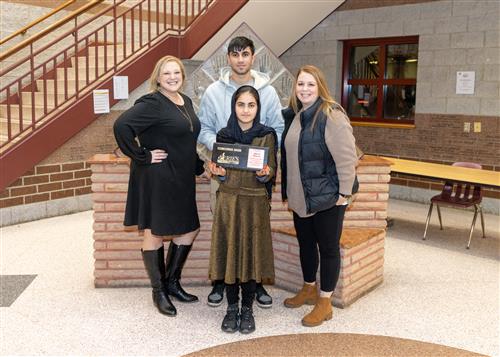 Afsana Dawood, Pfeiffer-Burleigh's December Stairclimber, poses with her plaque, family members and school staff.