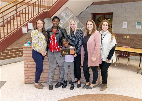 Brooklyn Butler, Edison's December Stairclimber, poses with her plaque, family members and school staff.
