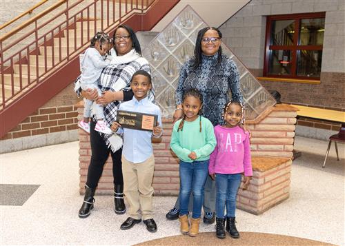 Lamont McKinney, Eagle's Nest Stairclimber for December, poses with his plaque and family members.