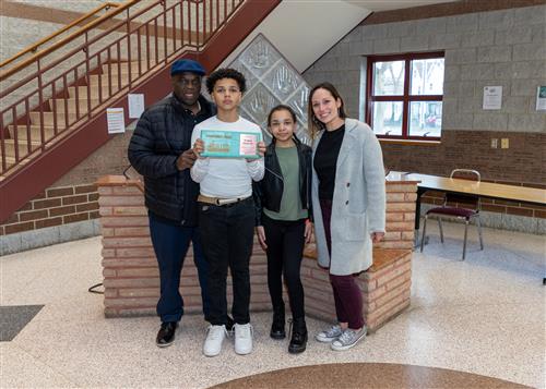 Roman Vitale, Jr., Wilson's March Stairclimber, poses with his plaque, family members, and school staff.