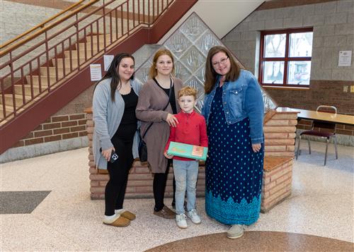 Adin Buric, Lincoln's March Stairclimber, poses with his plaque, family members, and Principal Huffman.