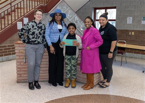 Uzziah Stewart, Grover Cleveland's March Stairclimber, poses with his plaque, family members, and school staff.