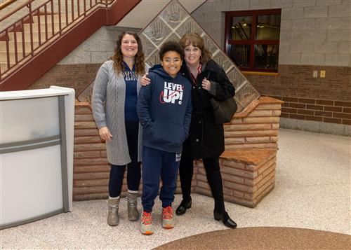 Aiden Herbert, Strong Vincent's November 2022 Stairclimber, posing with a family member and Principal Andrea Gloystein.