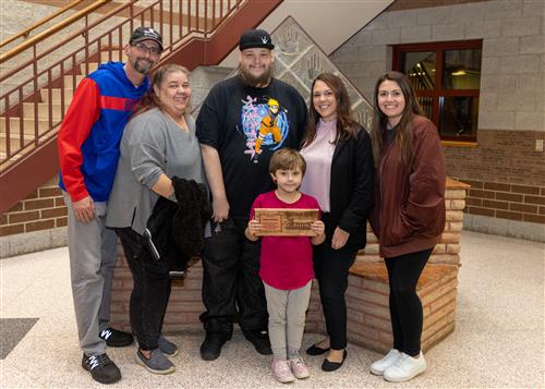 Emma Lijewski. Pfeiffer-Burleigh's November 2022 Stairclimber, posing with family and Principal Jamie Petruso.