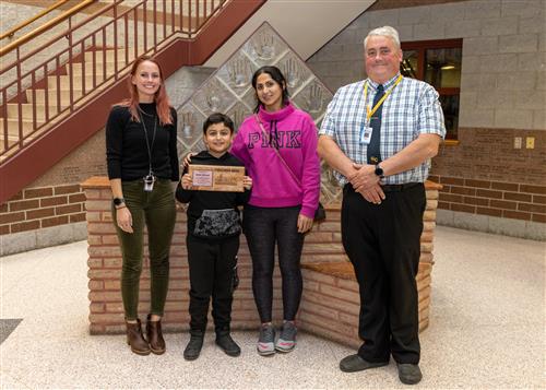 Badar Moradi, Grover Cleveland's November 2022 Stairclimber, posing with family and Asst. Principal Dennis Carner.