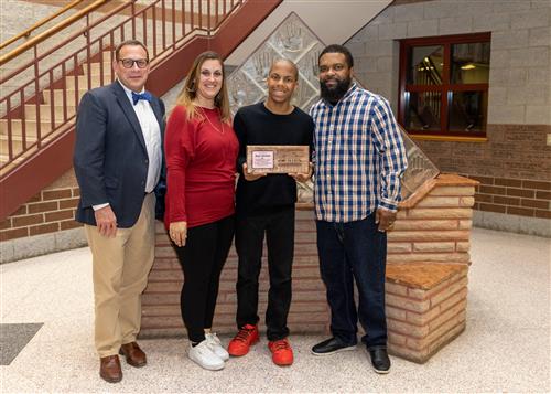 Mark Mitchell Jr., Collegiate Academy's November 2022 Stairclimber, posing with family and Dean Jim Vieira.