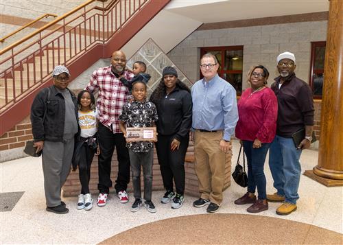 Kyleon Bethea, McKinley's November 2022 Stairclimber, posing with family members and Principal Dana Suppa.