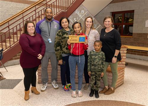 Andraya Henderson, Wilson's December Stairclimber, posing with her plaque and family members.