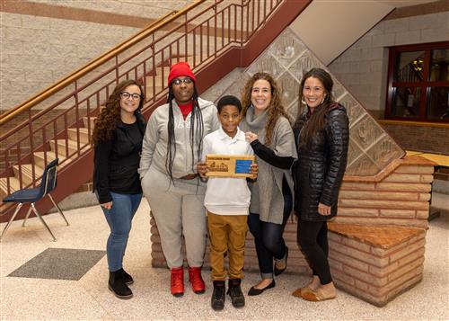 Davon McLaurin, Edison Elementary's December Stairclimber, posing with his plaque, family members, and school administrators.