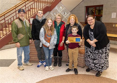 Xavier Hodges, Lincoln Elementary Stairclimber for December, posing with his plaque, family members and Principal CJ Huffman.