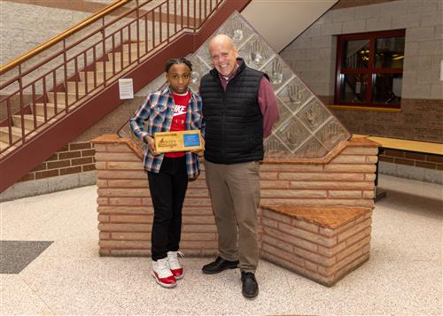 Roosevelt Benjamin, Harding Elementary's December Stairclimber, posing with his plaque and Assistant Principal Jeff Yonkers.