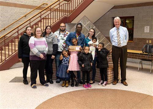 Marielys Mugisha-Rodriguez, Diehl's January 2023 Stairclimber, stands with family and Principal Sabol.