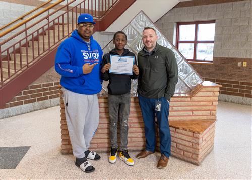 Photo of East Stairclimber Jaylin Burrows standing with Principal Jesse Williams and family member.