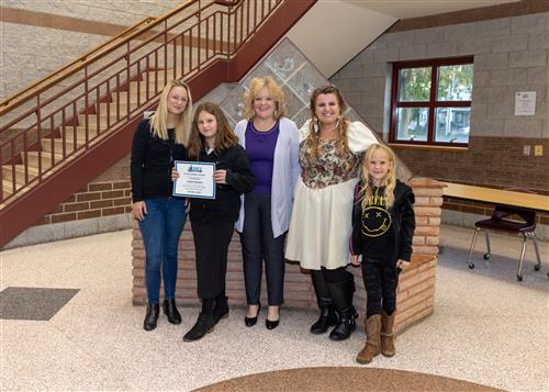 Cassie Stockton, Diehl Elementary's October Stairclimber, poses with her certificate, family members, and AP Kearney.