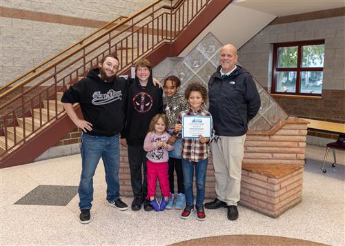 Romeo Semenyakov, Harding's October Stairclimber, poses with his certificate, family members, and Asst. Principal Yonkers.