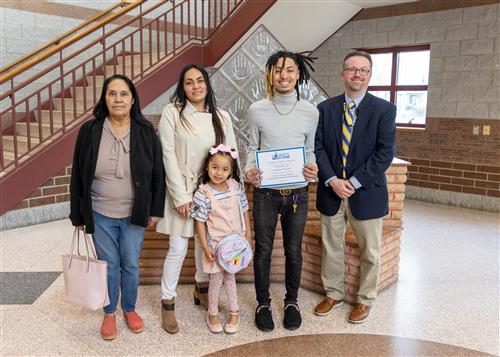 Photo of Gabriel Flores, family members, and Assistant Principal Dr. Eric Sandberg.