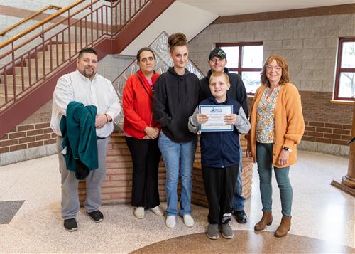 Photo of Brandon White, family members, and JoAnna Connell Principal Rob Causgrove.