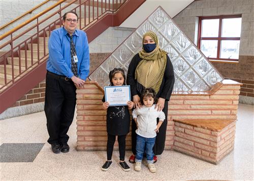 Photo of Mahdesa Mohammadi, family members, and Principal Jason Burgert.
