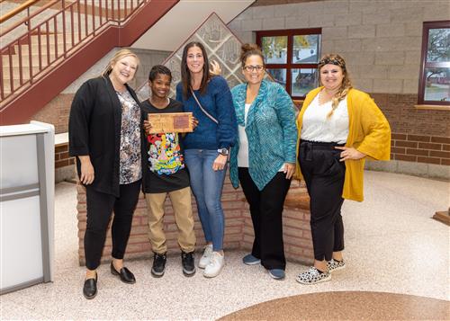 K'Lup Davis, Pfeiffer-Burleigh's October 2022 Stairclimber, posing with teachers and school administrators.