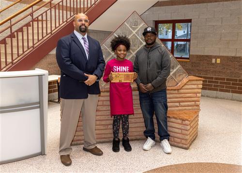 Harmony Thurston, McKinley Elementary School's October 2022 Stairclimber, posing with family and DEI Coordinator Ken Nickson.