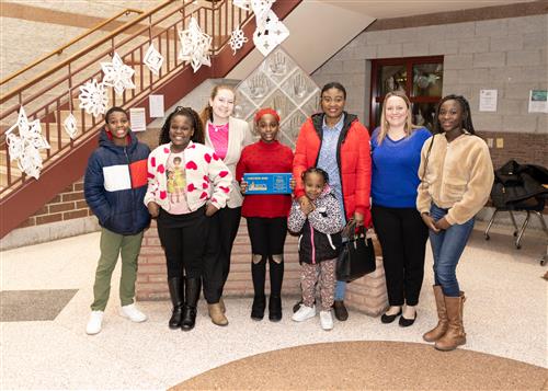 Blessing Kambowa, Grover Cleveland's January Stairclimber, poses with her plaque, family members, and school staff. 