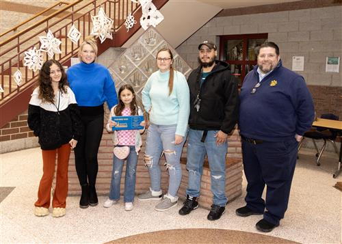 Layleanna Torres, JoAnna Connell's January Stairclimber, poses with her plaque, family members, and school staff.