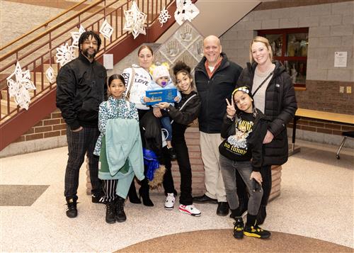 Zariyah Gimore, Harding's January Stairclimber, poses with her plaque, family members, and school staff.