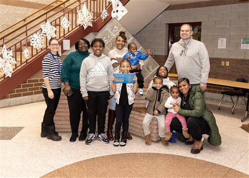 Zerenity Gambill-Tate, Jefferson's January Stairclimber, poses with her plaque, family members, and Principal Boam.