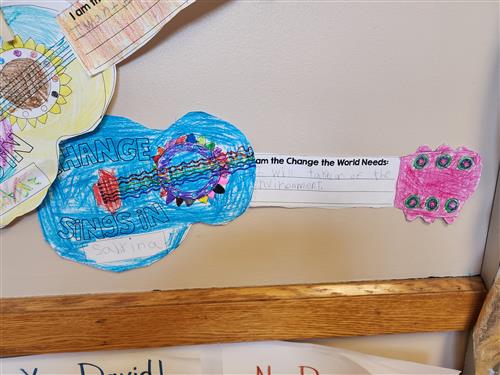 Picture of two paper guitars colored and decorated by second-grade students at Jefferson.