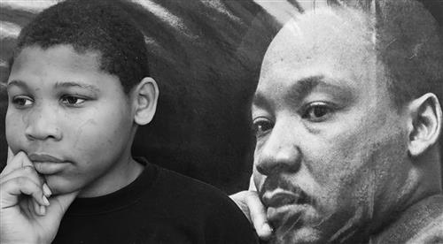 Photo is a composition of a current male student posing in the same pose as a famous profile picture of MLK Jr., hand on chin