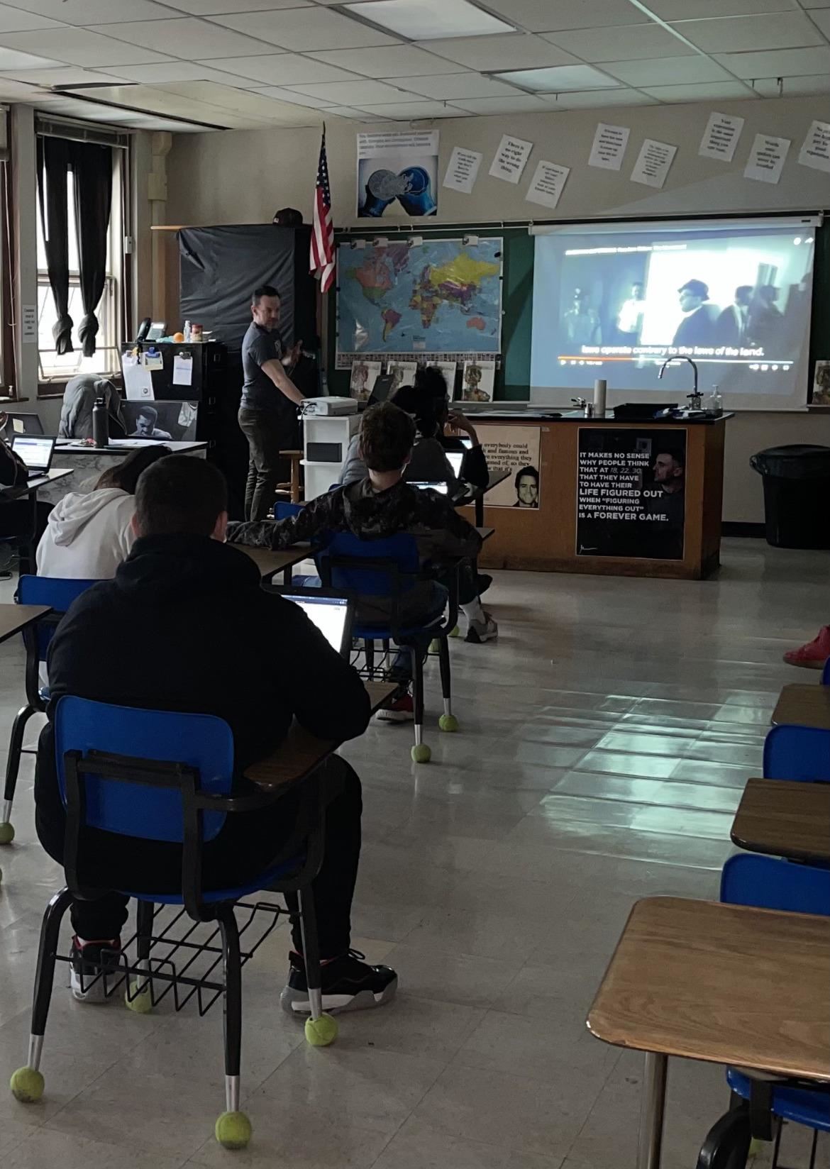Photo of students learning in a classroom, watching a video about the Freedom Riders.